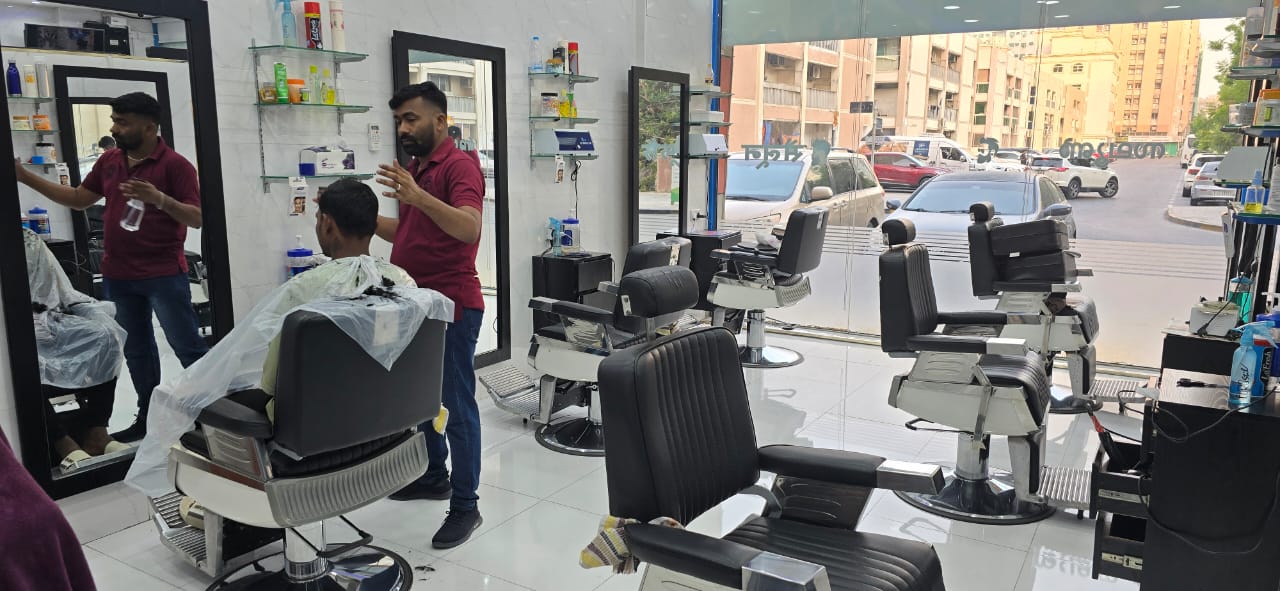 Barber giving a haircut at Golden Bow Gents Salon.